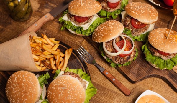 Top view of classic cheesburgers next to french fries. Fast food. Grilled beef meat.